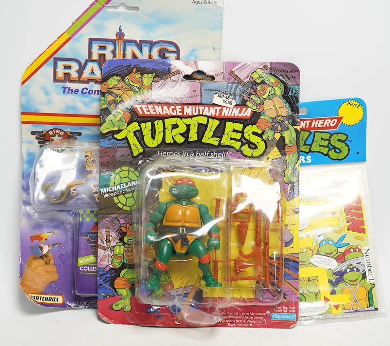 A Playmates Teenage Mutant Ninja Turtles figure of Michaelangelo, dated 1988, a Teenage Mutant Hero Turtles packeted ‘Teasers’, dated 1990, and a Matchbox Ring Raiders toy. Condition - fair to good, some creases to backi